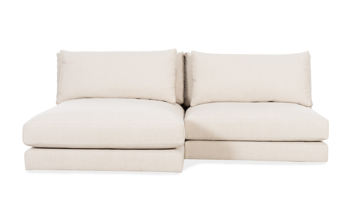 Låg beige divansoffa i ljust rum, sittdynan nära golvet