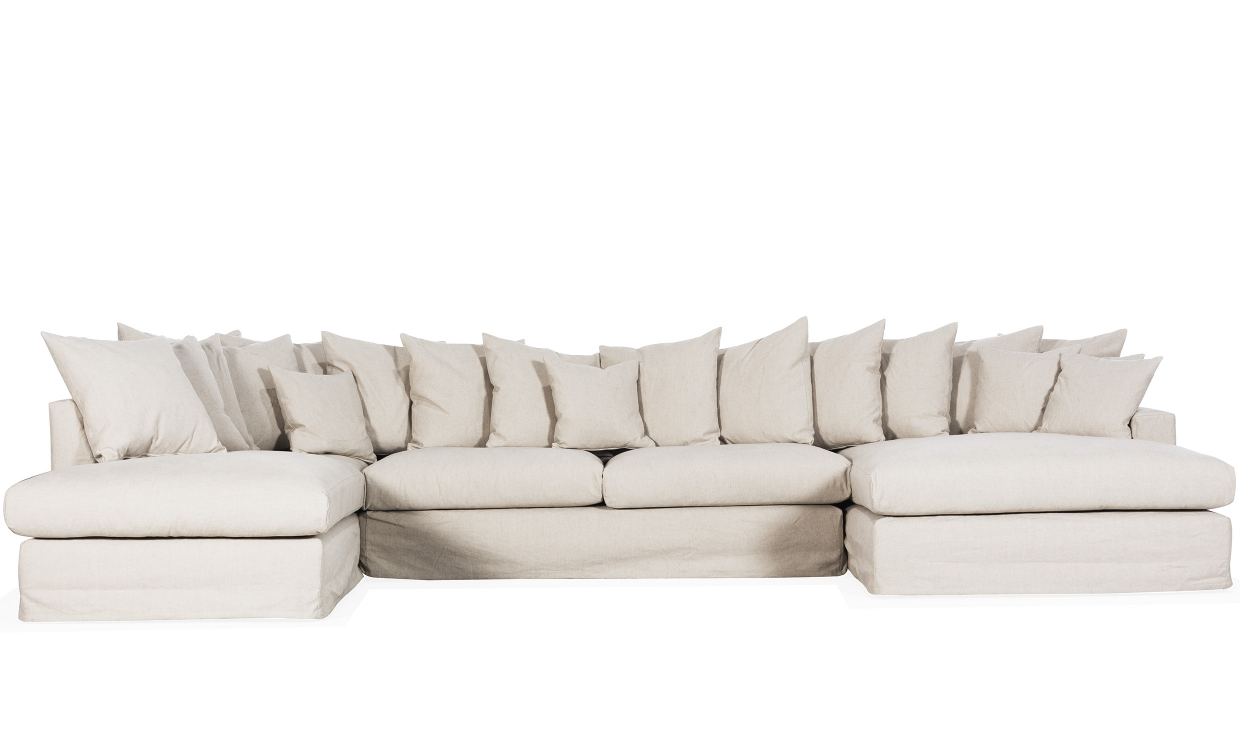 Stor beige U-soffa i ljust rum