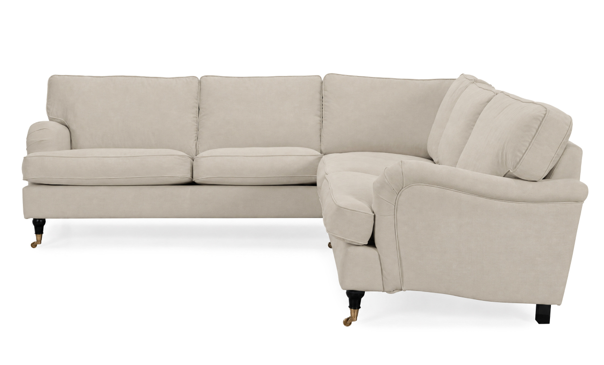 Beige symmetrisk howard-hörnsoffa med veckade armstöd